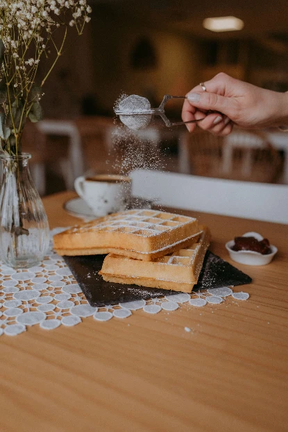 Świeże gofry posypywane cukrem pudrem w kawiarni w Radomiu